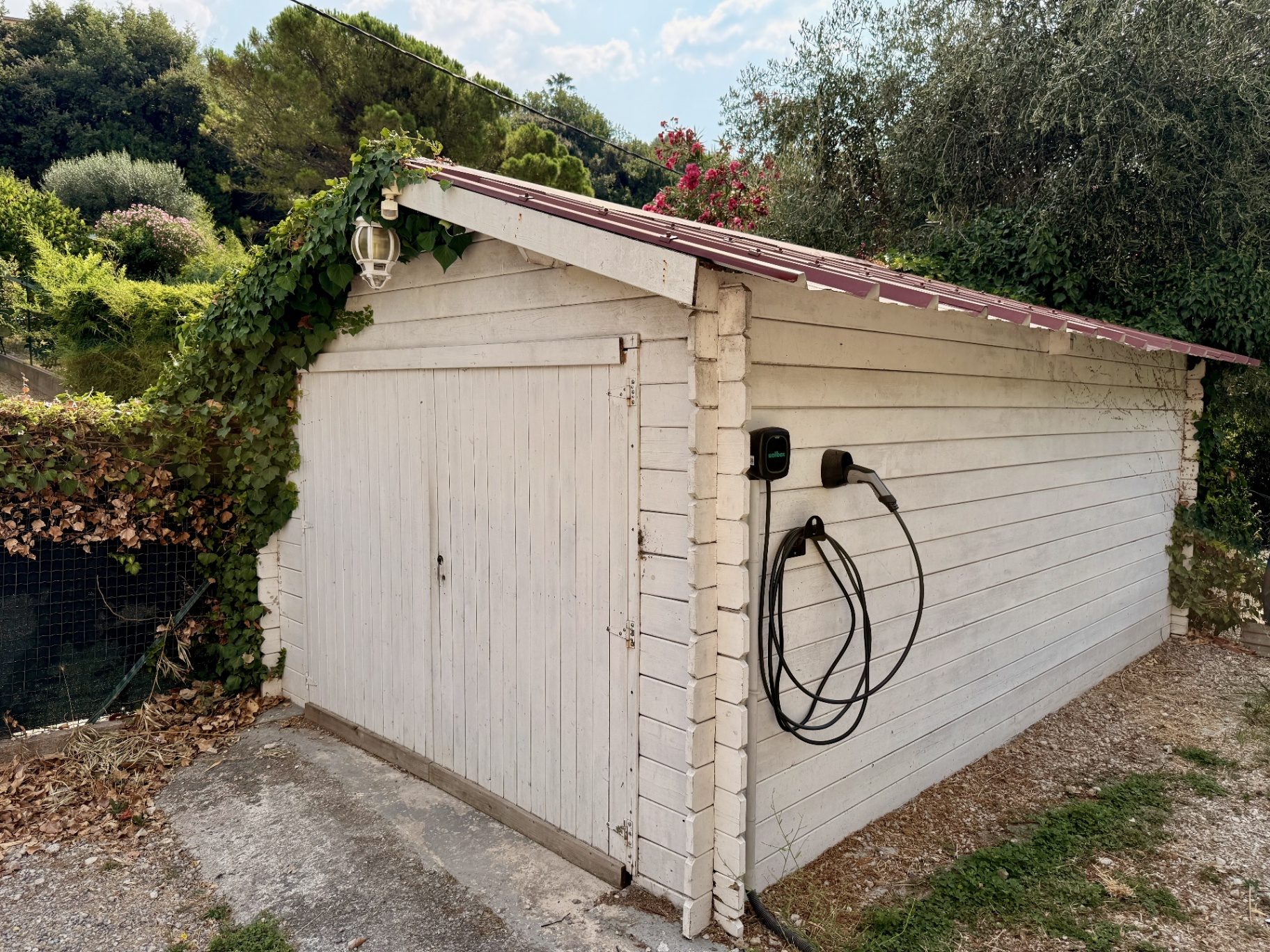 Grand cabanon blanc en bois avec borne de recharge Wallbox