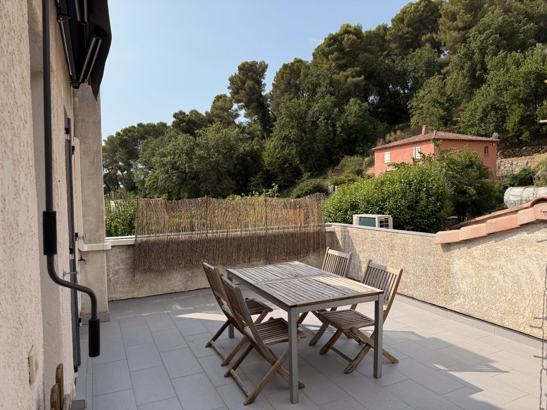 Terrasse privative du 2 pièces avec table et vue sur les collines